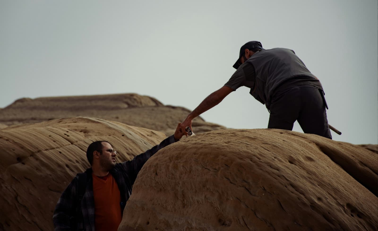 One person helping another across a difficult climb