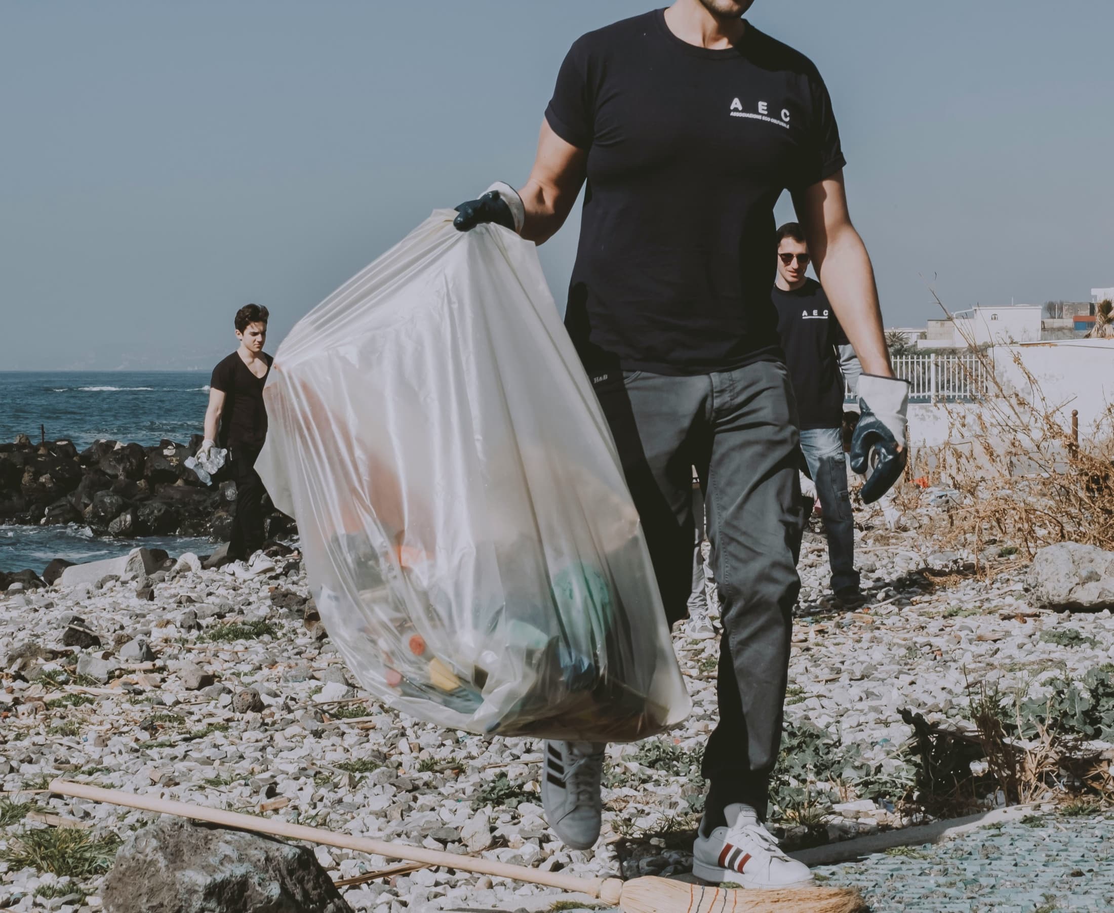 Community volunteers cleaning waste from a rocky shoreline
