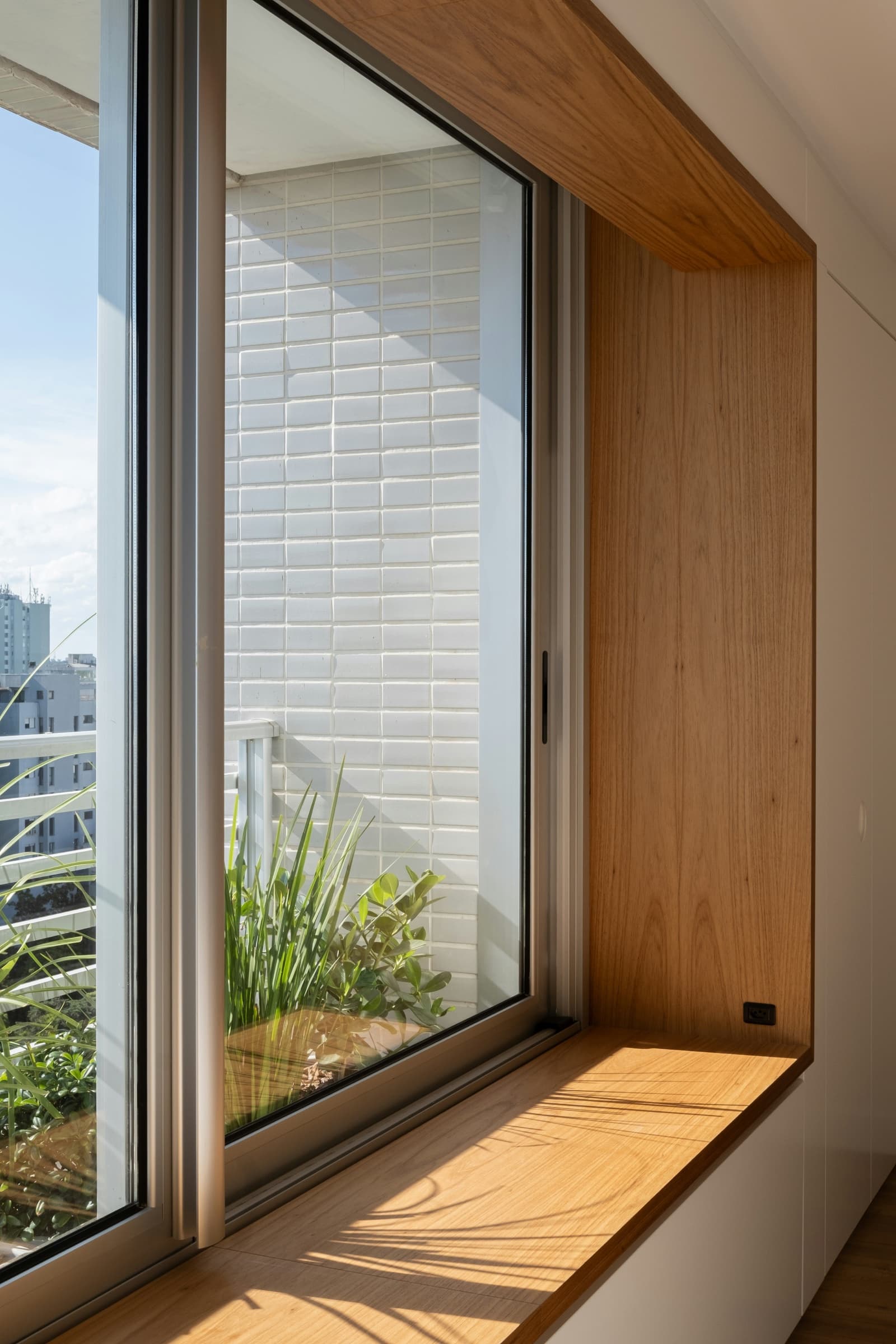 Modern sliding window with a deep wood-lined sill
