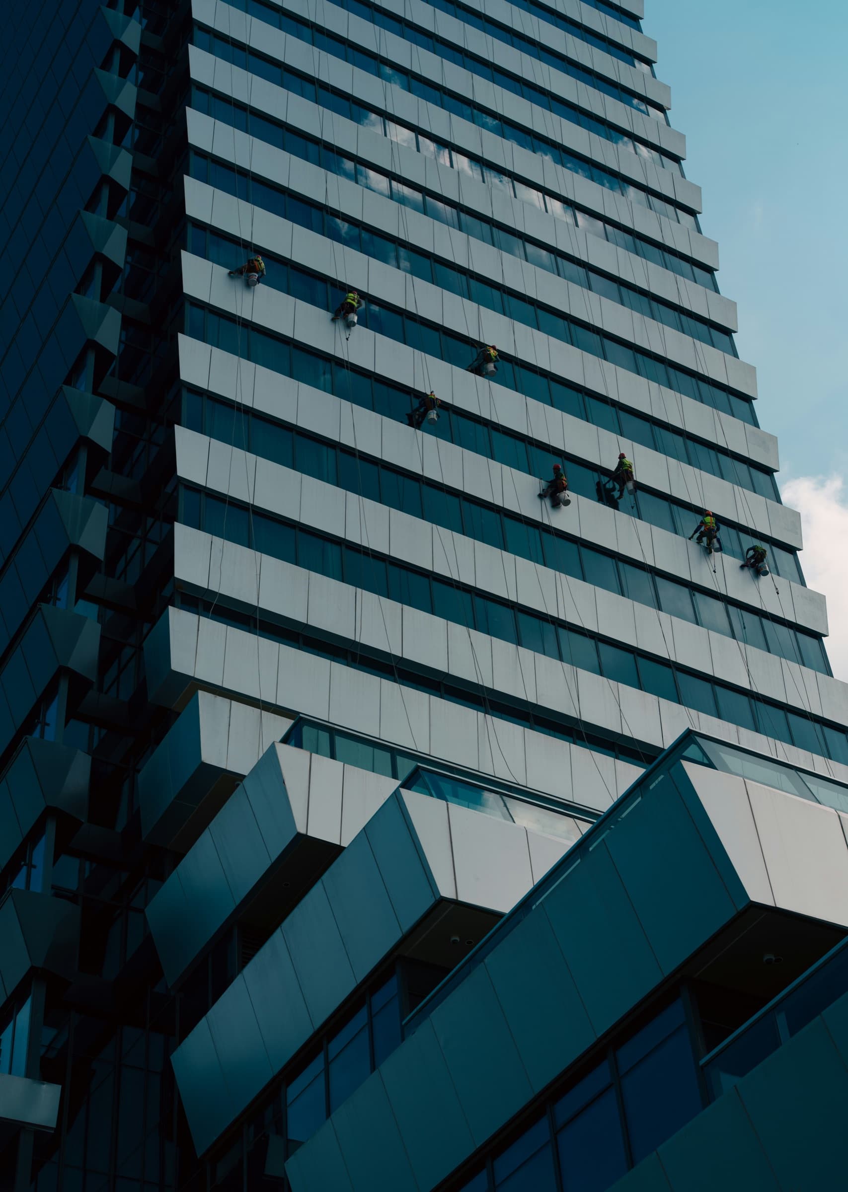Commercial glazing professionals working on a high-rise window facade