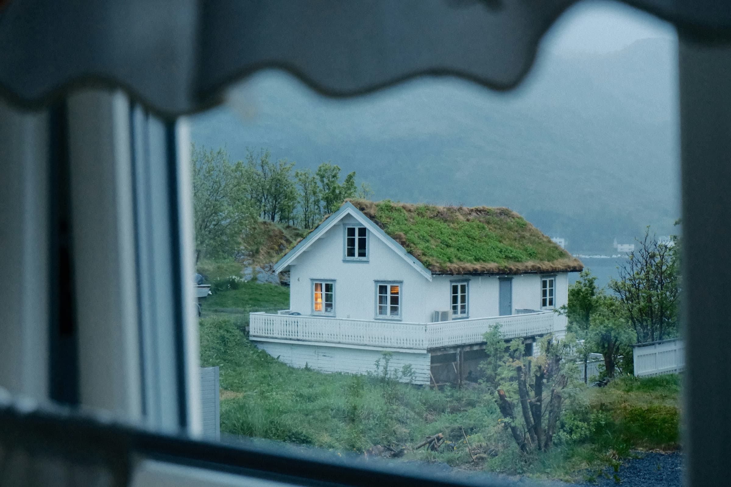 White coastal home seen through a window during stormy weather